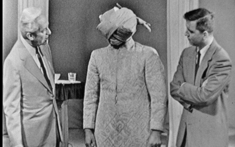 Left to right, Art Baker, Kuda Bux (blindfolded with several bandages), Robert Baldwin
